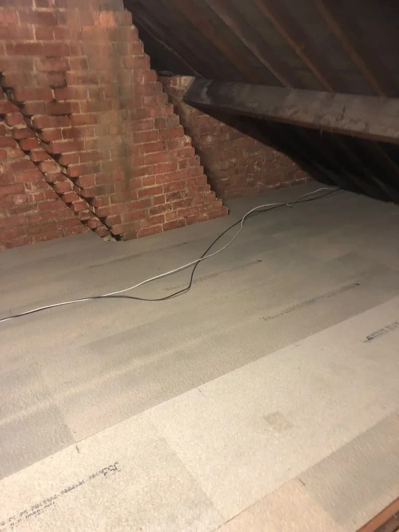 Completed loft boarding fitted around a brick chimney