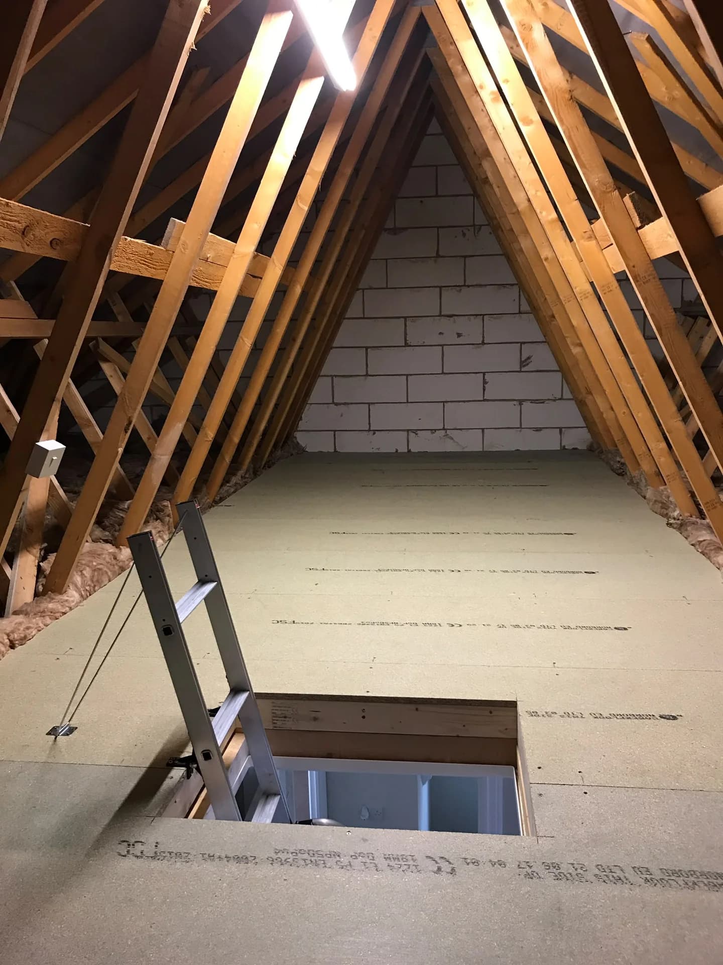 A boarded loft with a fitted access ladder, installed by KMW Loft Ladders